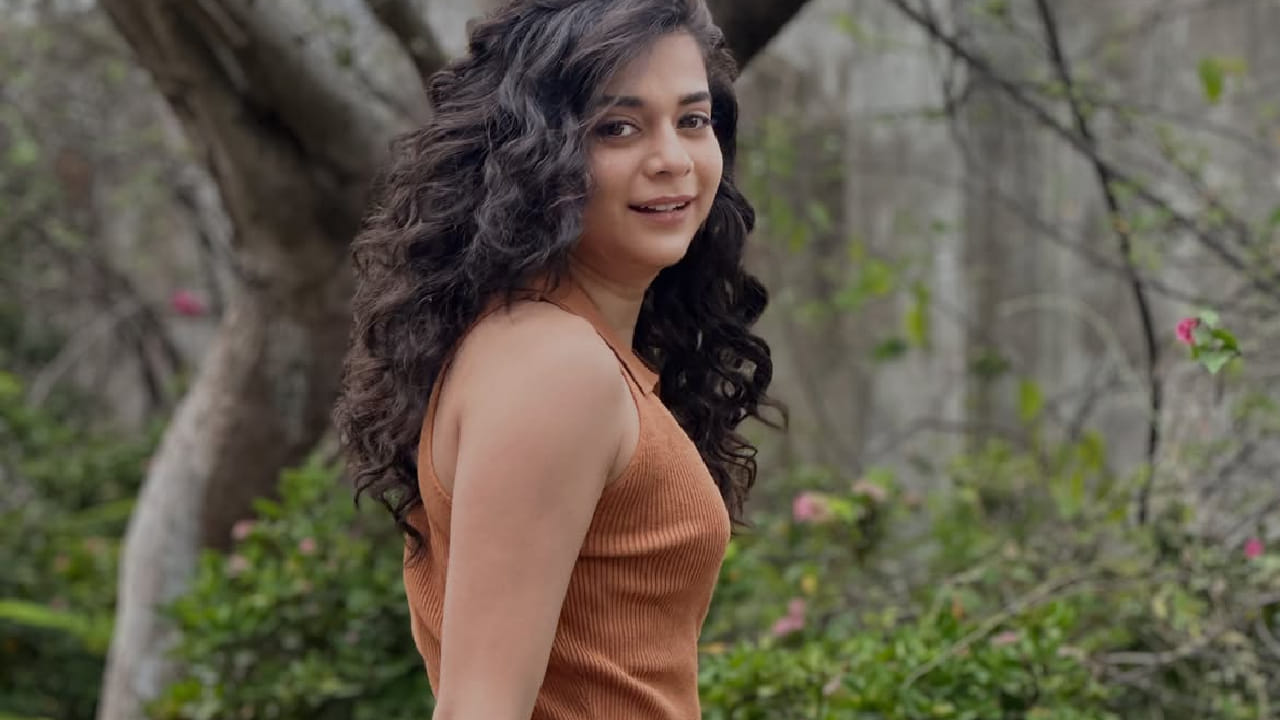 Actress Mithila Palkar posing in a stylish crop top and denim jeans